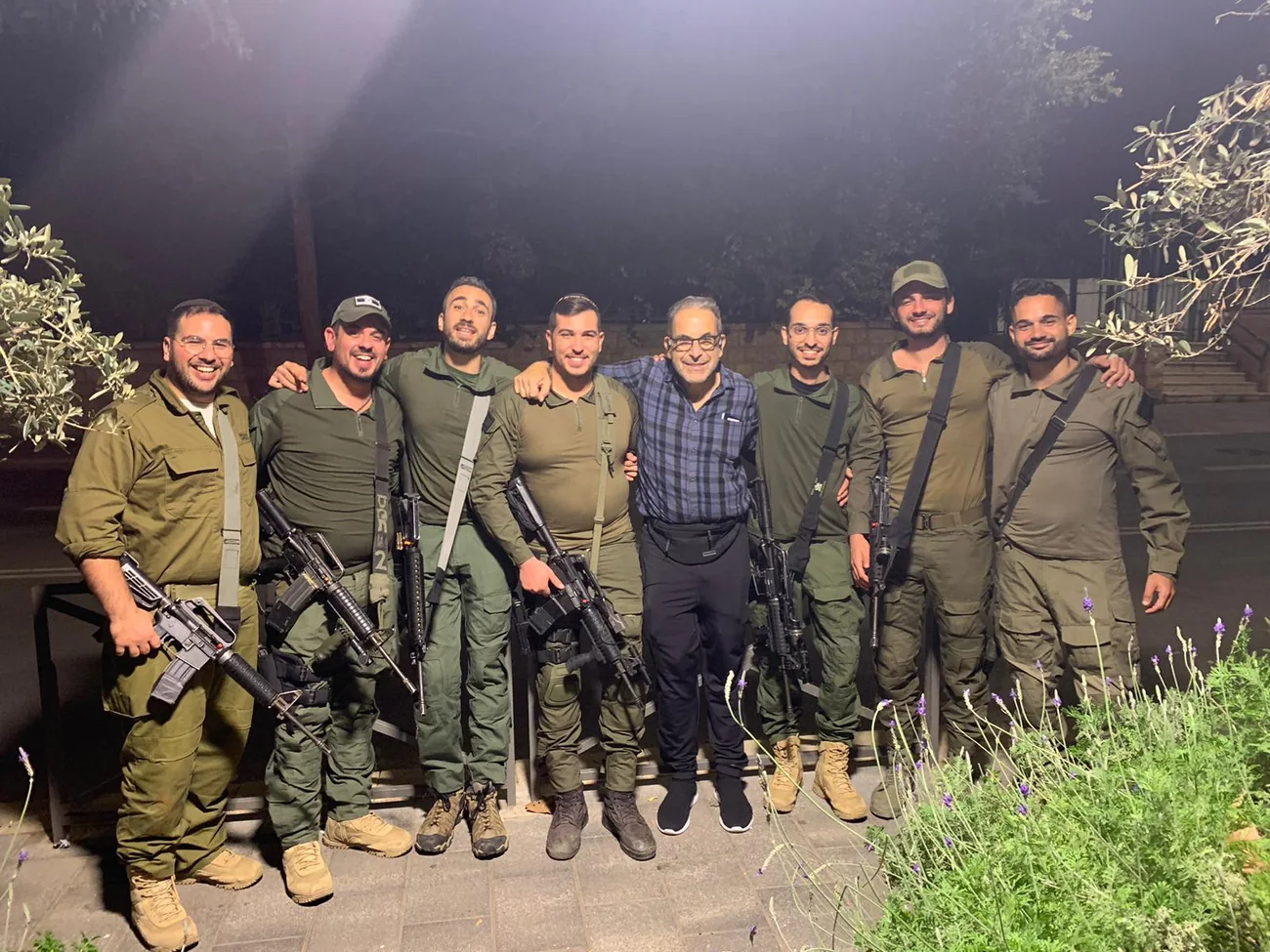 A line of Israeli soldiers in uniform standing outdoors with Ivan Sacks