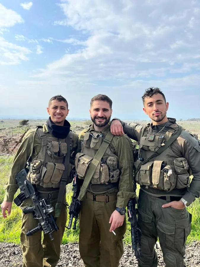 Three Israeli soldiers in full gear standing together outdoors