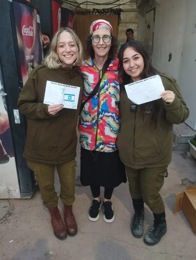 Two Israeli soldiers and a volunteer holding letters they have just been given